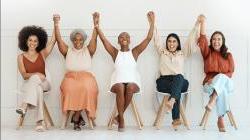 Business women holding hands up together in celebration
